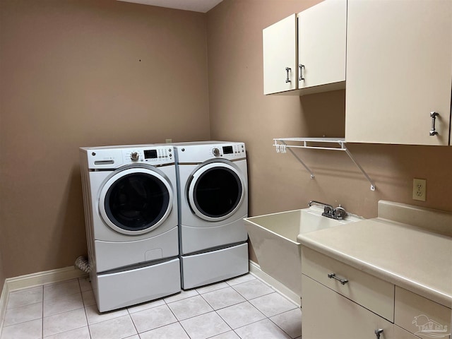 laundry room with baseboards, cabinet space, separate washer and dryer, and light tile patterned flooring