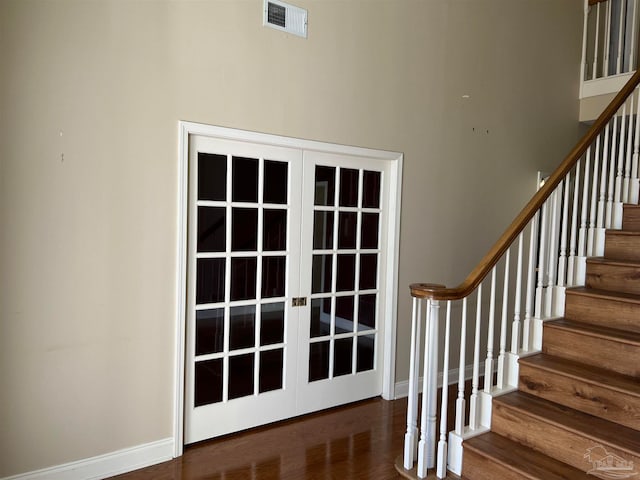 stairs with visible vents, french doors, baseboards, and wood finished floors