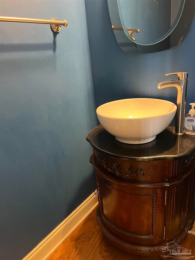 bathroom with vanity, wood finished floors, and baseboards