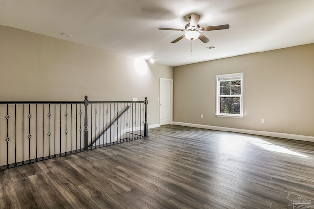 unfurnished room featuring dark wood-type flooring and ceiling fan