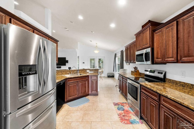 kitchen with light stone counters, light tile patterned floors, vaulted ceiling, sink, and stainless steel appliances