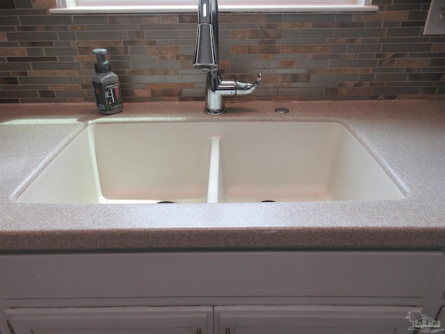 room details with decorative backsplash, light countertops, and a sink