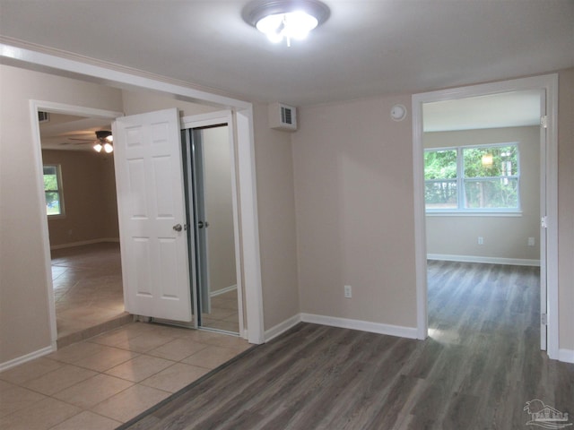 unfurnished room with a ceiling fan, baseboards, a healthy amount of sunlight, and wood finished floors