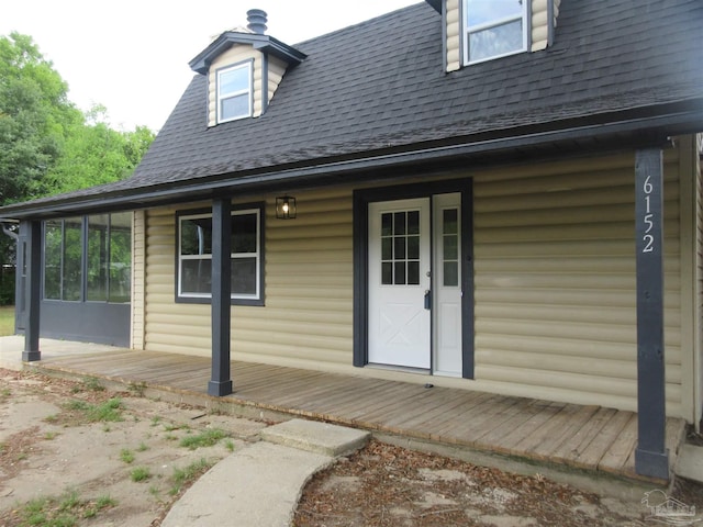 doorway to property with roof with shingles