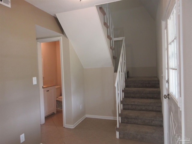 stairs with baseboards, tile patterned flooring, visible vents, and plenty of natural light