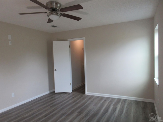 spare room with baseboards, a ceiling fan, wood finished floors, and visible vents