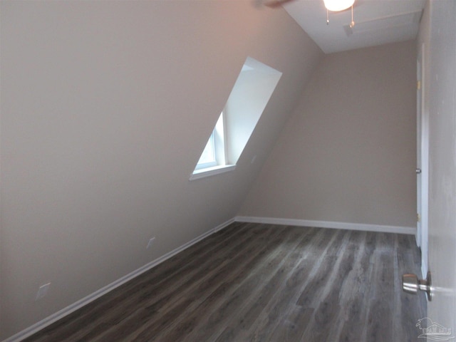 additional living space with dark wood finished floors and baseboards