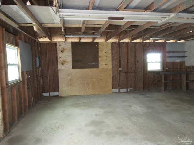 miscellaneous room featuring a wealth of natural light, unfinished concrete flooring, and a garage