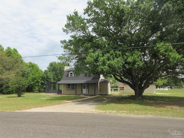 view of front facade featuring dirt driveway and a front yard