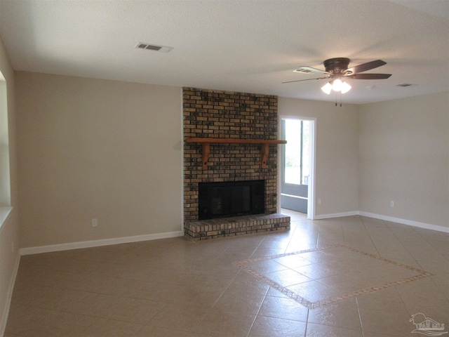 unfurnished living room with tile patterned flooring, visible vents, a ceiling fan, baseboards, and a fireplace