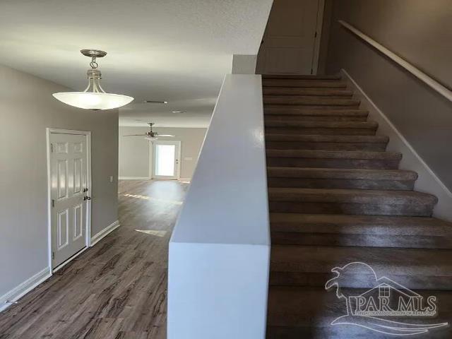 stairs with ceiling fan and wood-type flooring