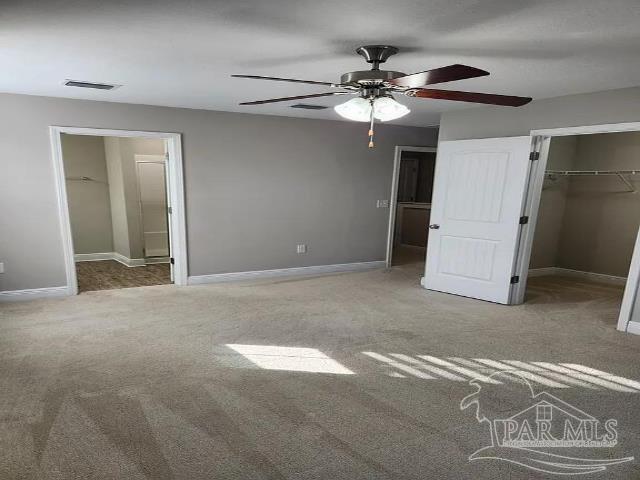 unfurnished bedroom featuring carpet floors, ceiling fan, and a closet