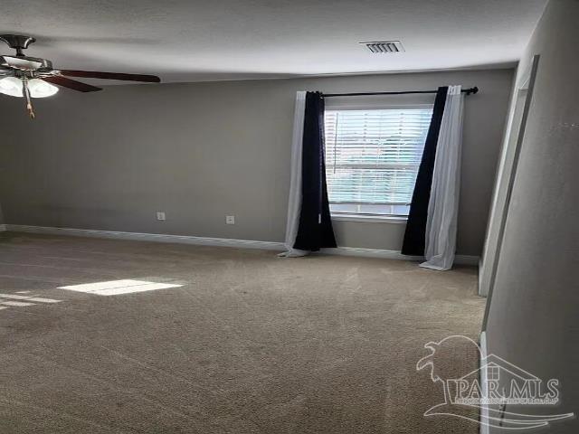 carpeted spare room featuring ceiling fan