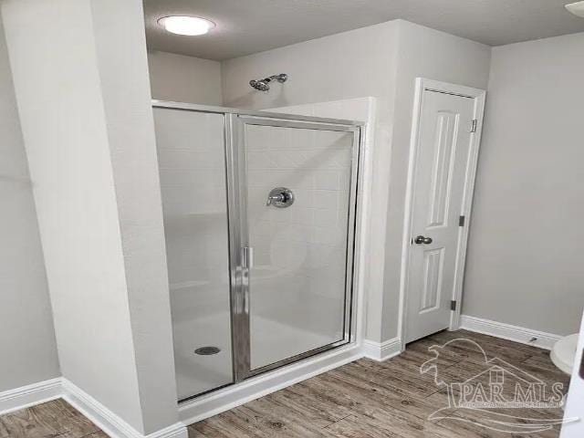 bathroom with hardwood / wood-style floors and walk in shower