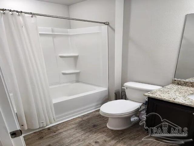 full bathroom with vanity, hardwood / wood-style flooring, toilet, and shower / tub combo with curtain