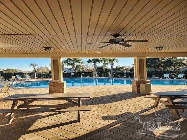 view of swimming pool featuring ceiling fan and a patio area