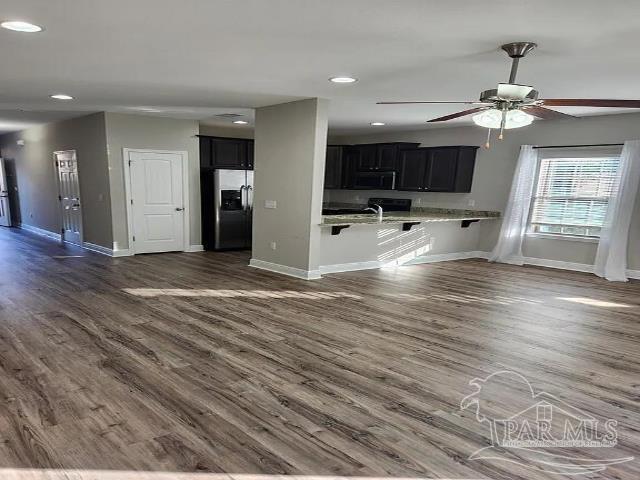 kitchen featuring stainless steel refrigerator with ice dispenser, dark hardwood / wood-style floors, sink, and ceiling fan