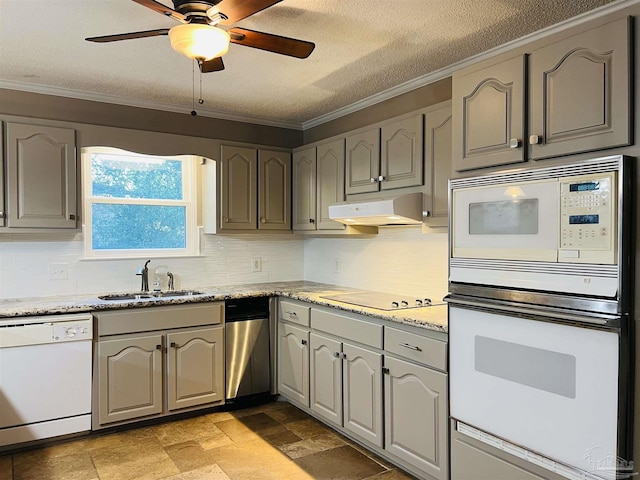 kitchen with white appliances, ornamental molding, sink, a textured ceiling, and tasteful backsplash