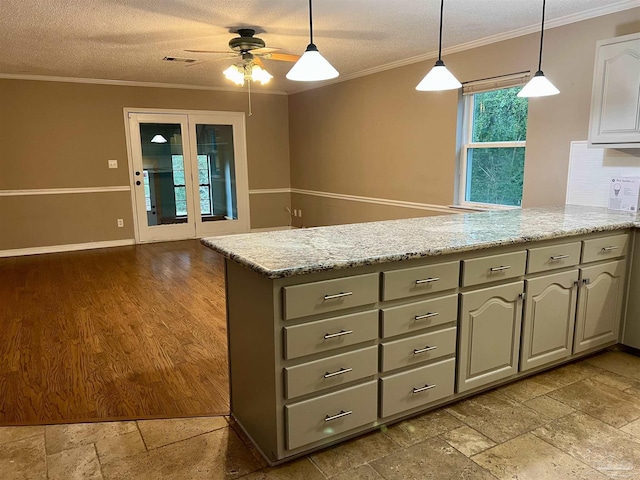 kitchen with light stone counters, a textured ceiling, crown molding, gray cabinetry, and ceiling fan