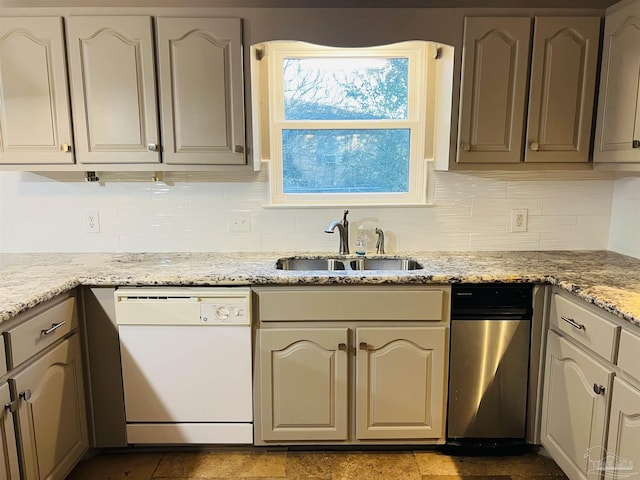 kitchen with white dishwasher, tasteful backsplash, light stone counters, and sink