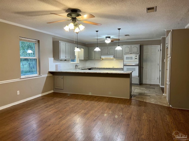 kitchen with white appliances, ornamental molding, backsplash, and kitchen peninsula