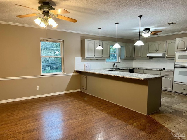 kitchen with white appliances, crown molding, kitchen peninsula, ceiling fan, and backsplash