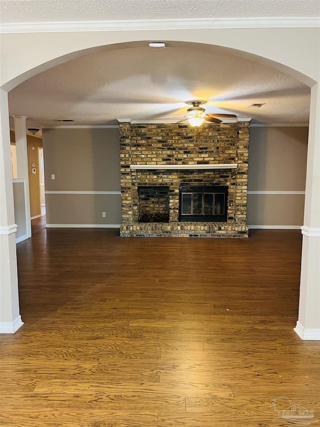 unfurnished living room with a textured ceiling, crown molding, a fireplace, and hardwood / wood-style flooring