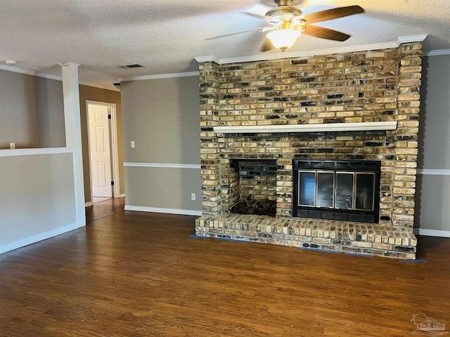 unfurnished living room featuring a brick fireplace, a textured ceiling, dark wood-type flooring, and ornamental molding