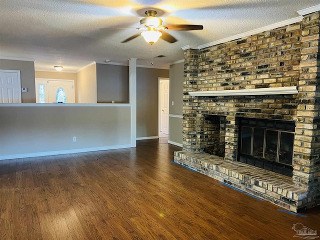 unfurnished living room featuring a brick fireplace, a textured ceiling, ornamental molding, and hardwood / wood-style floors