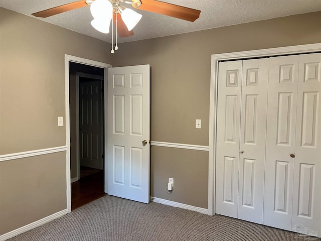 unfurnished bedroom with a textured ceiling, carpet floors, ceiling fan, and a closet