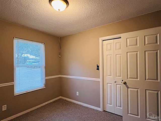 carpeted spare room featuring a textured ceiling