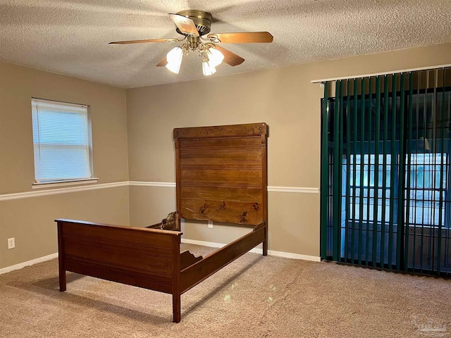 carpeted bedroom featuring a textured ceiling and ceiling fan