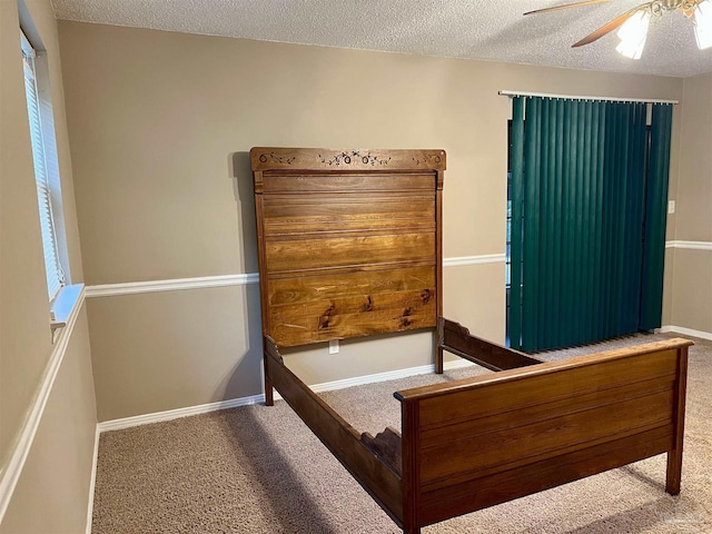 carpeted bedroom with a textured ceiling and ceiling fan