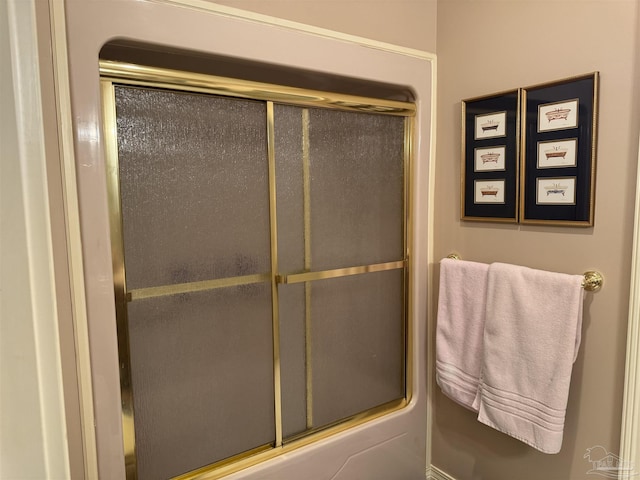 bathroom featuring combined bath / shower with glass door