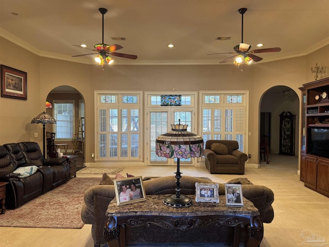 carpeted living room with crown molding and ceiling fan