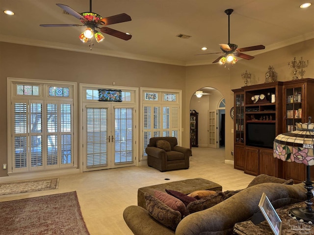 carpeted living room with crown molding, ceiling fan, and french doors