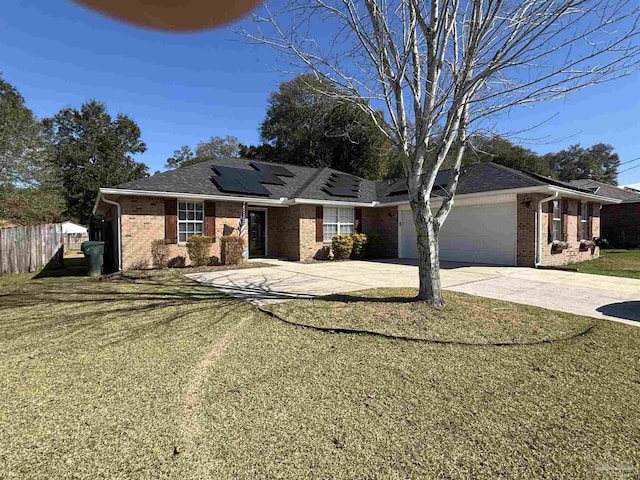 ranch-style house with solar panels, an attached garage, fence, driveway, and a front lawn