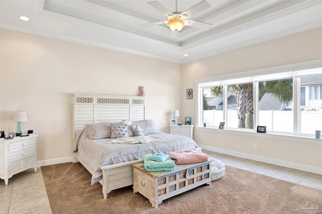 bedroom featuring ceiling fan, multiple windows, and a tray ceiling