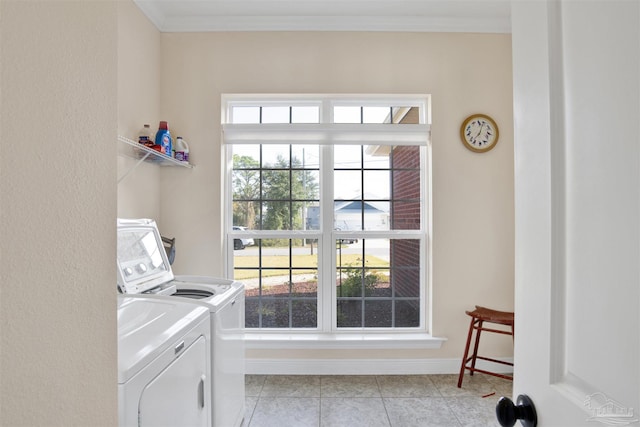 laundry area with light tile patterned flooring, crown molding, and washing machine and clothes dryer