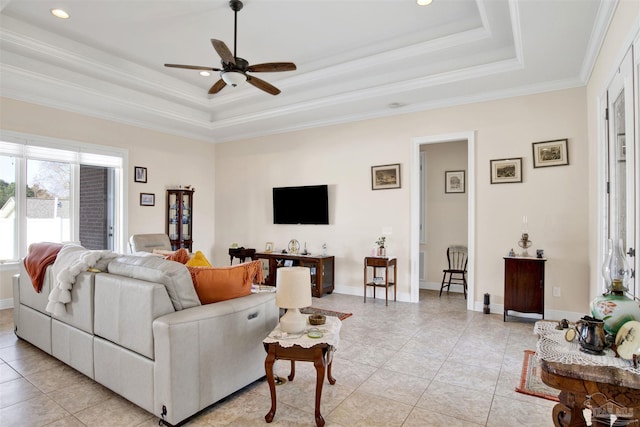 tiled living room featuring a raised ceiling, ceiling fan, and ornamental molding