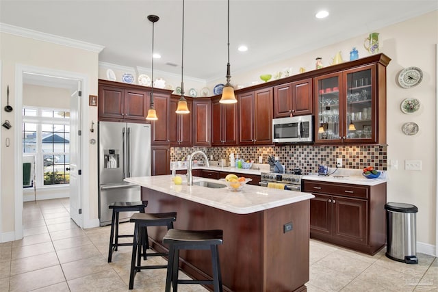 kitchen with stainless steel appliances, a kitchen breakfast bar, pendant lighting, decorative backsplash, and light tile patterned floors