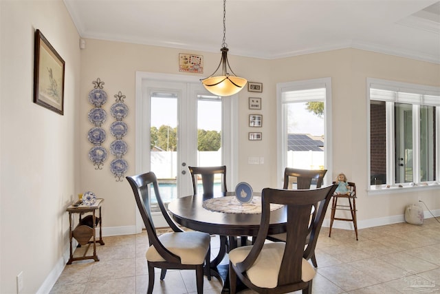 tiled dining space with french doors, plenty of natural light, and crown molding