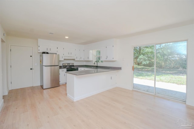 kitchen with kitchen peninsula, sink, appliances with stainless steel finishes, white cabinets, and light hardwood / wood-style floors