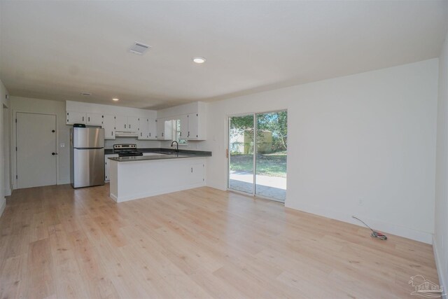 kitchen featuring light wood-type flooring, kitchen peninsula, sink, appliances with stainless steel finishes, and white cabinets