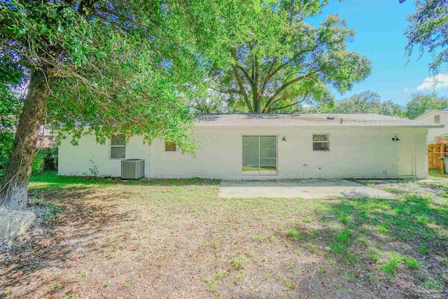 back of house with cooling unit, a lawn, and a patio