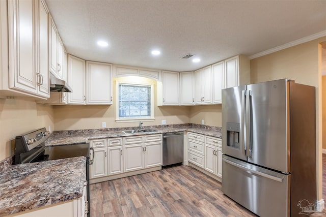 kitchen with white cabinets, stainless steel appliances, crown molding, hardwood / wood-style flooring, and sink