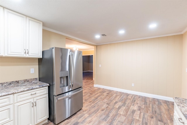 kitchen featuring light wood-type flooring, stainless steel fridge, ornamental molding, and white cabinetry