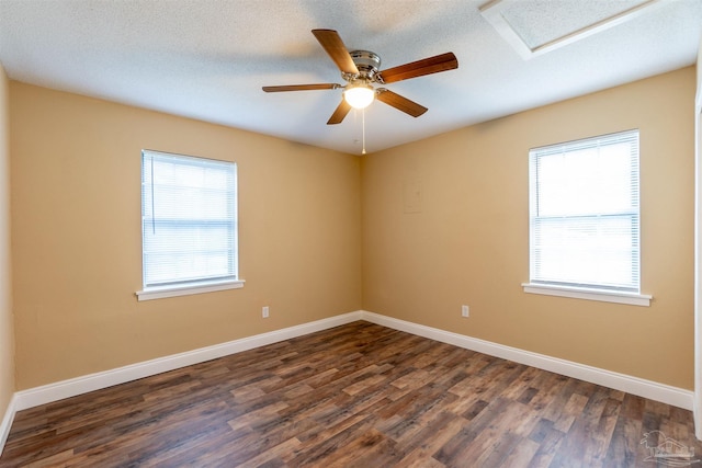 spare room featuring ceiling fan, a textured ceiling, plenty of natural light, and dark hardwood / wood-style floors