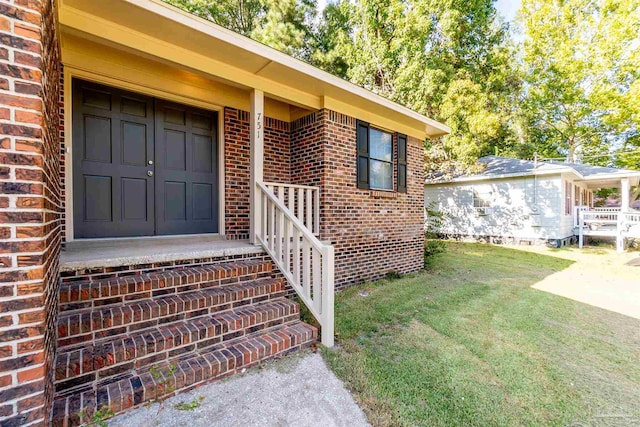 doorway to property featuring a lawn