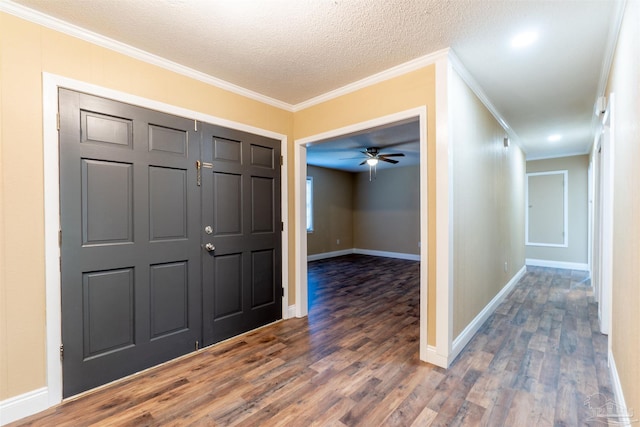 foyer entrance featuring a textured ceiling, crown molding, dark hardwood / wood-style flooring, and ceiling fan